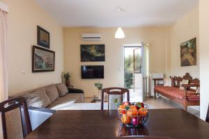 a living room with a table with a bowl of fruit on it at Domas Blue Studio Villa With Private Pool and Panoramic View in Loutra