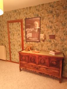een houten dressoir met een foto aan de muur bij Residenza nella campagna di Roma Capitale. in Rome