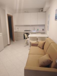 sala de estar con sofá, mesa y cocina en Corallo Cavallino, en Cavallino-Treporti