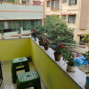 een balkon met groene krukken en potplanten. bij Lara stay 2bhk appartments in Calcutta