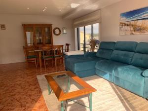 uma sala de estar com um sofá azul e uma mesa em ON the Beach/ Apartment With Pool em Apúlia