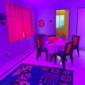 een eetkamer met een tafel met roze verlichting bij Lara stay 2bhk appartments in Calcutta