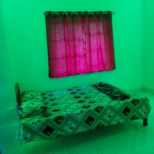 een groene slaapkamer met een bed met een roze gordijn bij Lara stay 2bhk appartments in Calcutta