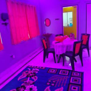 een eetkamer met een tafel met roze verlichting bij Lara stay 2bhk appartments in Calcutta