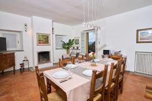 uma sala de jantar com uma mesa e cadeiras e uma televisão em [Villa Privata] Vista Mare - in Portovenere em Fezzano