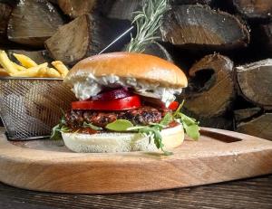 a sandwich on a wooden plate with french fries at Karczma u Wallenroda in Ryn