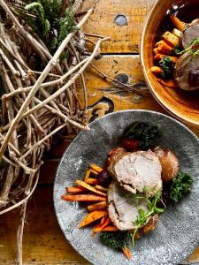 a plate of food with meat and carrots on a table at Karczma u Wallenroda in Ryn