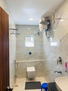 HOTEL MAA LAXMI PALACE في دوغار: حمام مع دش مع مرحاض ومغسلة