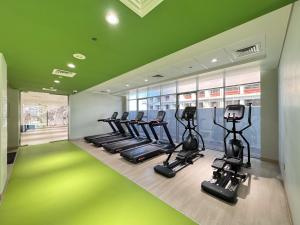 a gym with treadmills and ellipticals in a room at Comfy Azizi Aura Studio in Dubai