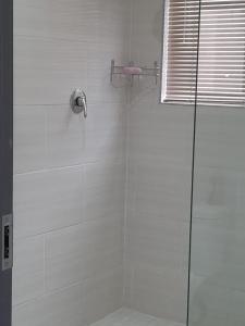 a bathroom with a shower with a glass door at Merensky house in Roodepoort