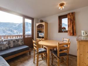 a dining room with a table and chairs and a window at Appartement La Clusaz, 2 pièces, 5 personnes - FR-1-304-33 in La Clusaz