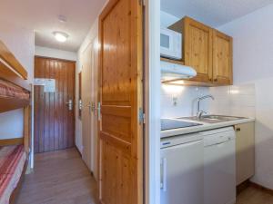 eine Küche mit Holzschränken und einem Waschbecken in der Unterkunft Studio La Clusaz, 1 pièce, 4 personnes - FR-1-304-30 in La Clusaz