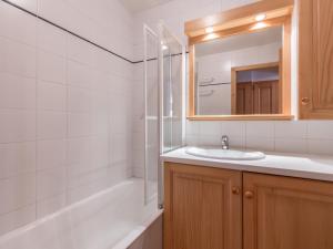 een badkamer met een wastafel, een spiegel en een bad bij Appartement La Clusaz, 3 pièces, 6 personnes - FR-1-304-133 in La Clusaz