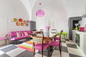 uma sala de estar com uma mesa e cadeiras cor-de-rosa em Carraio Salentino by BarbarHouse em Parabita