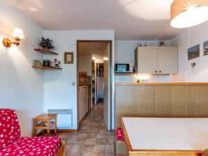 a living room with a red couch and a kitchen at Appartement La Clusaz, 2 pièces, 5 personnes - FR-1-304-38 in La Clusaz
