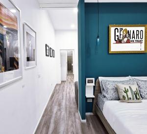 - une chambre avec un lit et un mur bleu dans l'établissement Napulitano Assaje Home, à Naples