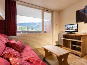 a living room with a couch and a tv at Studio La Clusaz, 1 pièce, 3 personnes - FR-1-304-264 in La Clusaz