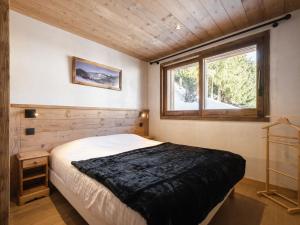 Un dormitorio con una cama grande y una ventana en Chalet La Clusaz, 6 pièces, 12 personnes - FR-1-304-270 en La Clusaz