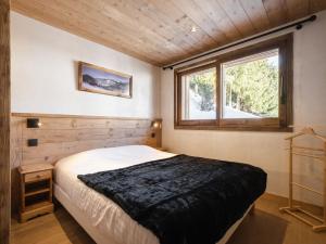 a bedroom with a large bed and a window at Chalet La Clusaz, 6 pièces, 12 personnes - FR-1-304-270 in La Clusaz