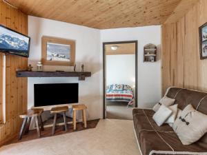 a living room with a couch and a television at Appartement La Clusaz, 3 pièces, 6 personnes - FR-1-304-151 in La Clusaz