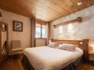 a bedroom with a large bed with a wooden ceiling at Appartement La Clusaz, 3 pièces, 4 personnes - FR-1-304-231 in La Clusaz