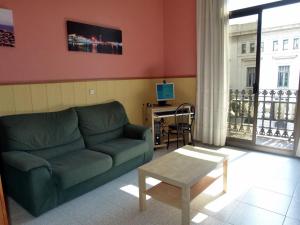 salon z zieloną kanapą i stołem w obiekcie Hostal Nuevo Colon w Barcelonie