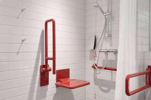 prysznic z czerwonym fotelem w łazience w obiekcie Days Inn Wetherby w mieście Wetherby