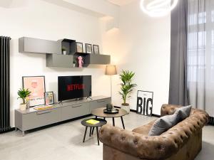 a living room with a couch and a tv at Diaz Novantuno - Luxury Apartments Como City Center in Como