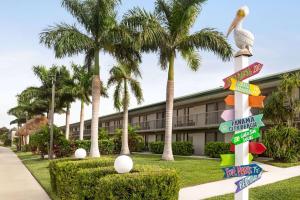 un edificio con palmeras y carteles callejeros en Ramada by Wyndham Sarasota Waterfront, en Sarasota