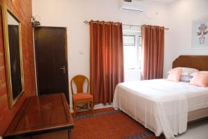 a bedroom with a bed and a table and a chair at Palm Grove in Colombo