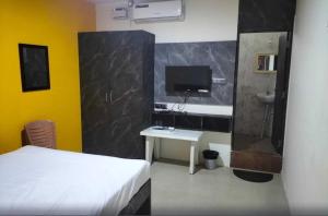 Navarang Residency Bar Top By Urban Express في بانغالور: غرفة نوم بسرير ومكتب وتلفزيون