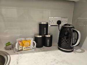 a kitchen counter with two coffee cups and a coffeemaker at Brand New Private Annex Guest Suite in Chandlers Ford