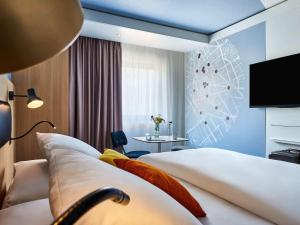a hotel room with two beds and a tv at Mercure Paris Gare De Lyon TGV in Paris