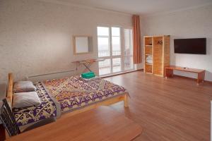 a room with a bed and a tv and a table at Grand Alatau in Astana