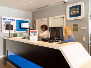 two people are working at a hospital counter at Ibis Budget Madrid Vallecas in Madrid