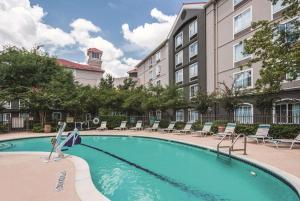 a swimming pool in front of a building at La Quinta by Wyndham Houston Bush IAH South in Houston