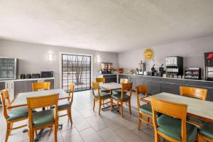 a restaurant with tables and chairs and a kitchen at La Quinta Inn by Wyndham San Antonio Lackland in San Antonio