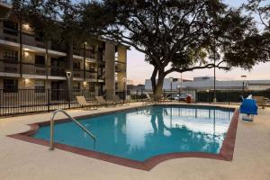 uma grande piscina em frente a um edifício em La Quinta Inn by Wyndham San Antonio I-35 N at Toepperwein em San Antonio