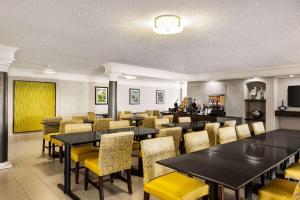 een eetkamer met tafels en gele stoelen bij La Quinta Inn by Wyndham San Antonio I-35 N at Toepperwein in San Antonio
