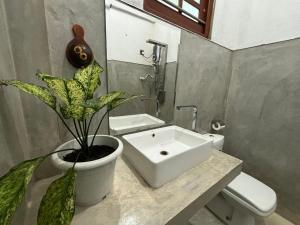a bathroom with a sink and a toilet and a plant at Water Angel Villa in Kamburugamuwa +23 photos