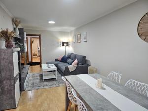 - un salon avec un canapé et une table dans l'établissement Apartamento Nara Playa, à Boiro