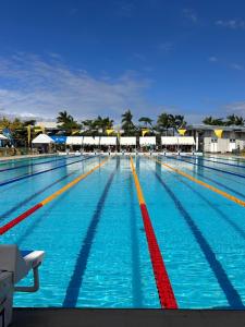 a large swimming pool with blue water and red lanes at Athlete's House in Imus