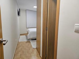 un couloir avec une chambre avec un lit et une fenêtre dans l'établissement Apartamento Nara Playa, à Boiro