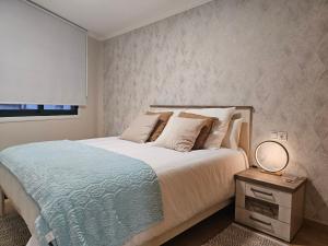 - une chambre avec un lit et une table avec un miroir dans l'établissement Apartamento Nara Playa, à Boiro