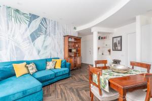 a living room with a blue couch and a table at Gregory 7House Vaticano in Rome