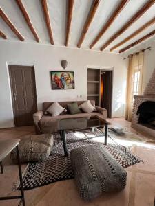 un soggiorno con divano e camino di Manzal Lahbab (Pavillons, Bungalows, Piscine et Jardins) a Marrakech