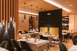 uma sala de jantar com mesas e cadeiras e um restaurante em Hotel Belvedere em San Martino di Castrozza
