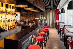 um bar com bancos vermelhos num restaurante em Amedia Linz, Trademark Collection by Wyndham em Linz