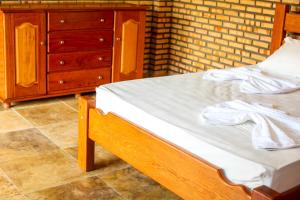 um quarto com uma cama de madeira e uma cómoda em pousada Baloiço em Caucaia
