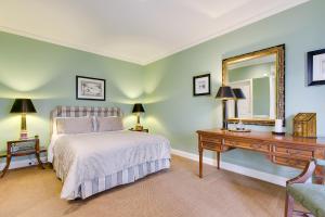 a bedroom with a bed and a desk and a mirror at Glen Isla House Bed & Breakfast Phillip Island in Cowes